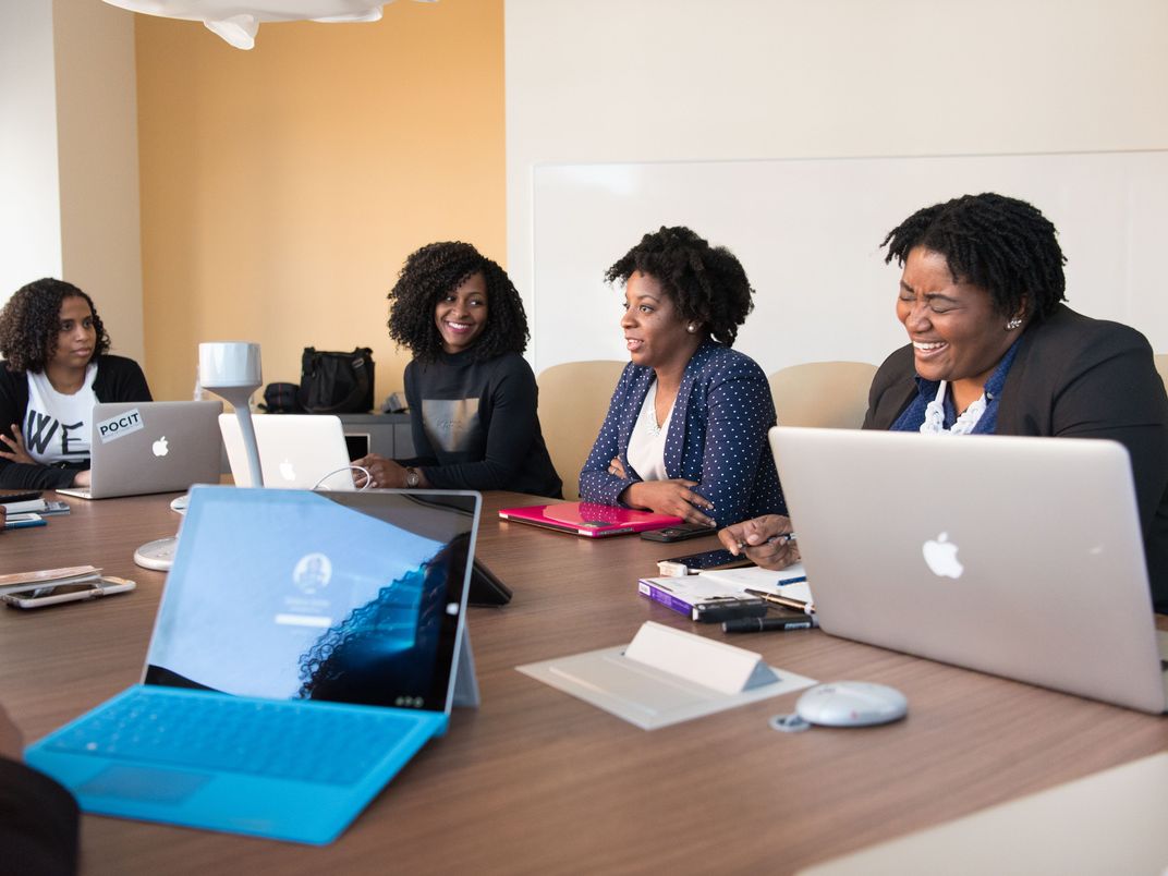 Investors in discussion around a boardroom table