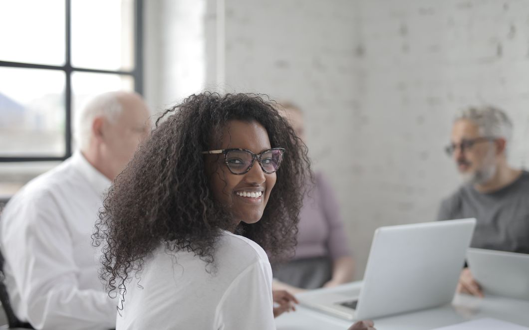 A client turning from her laptop during a working session with advisers